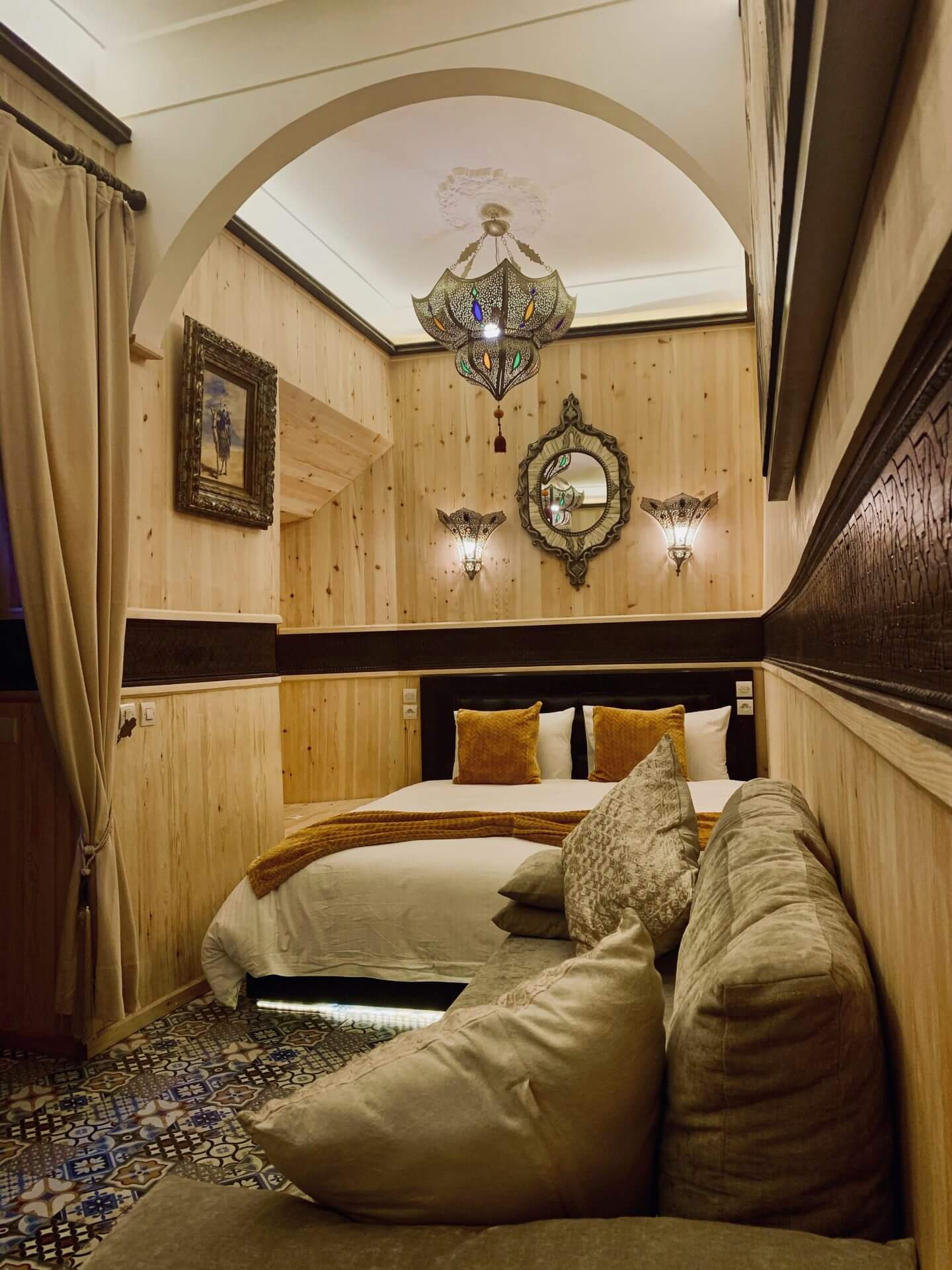 marokkanisches Schlafzimmer mit Holzwänden, Doppelbett und Couch
