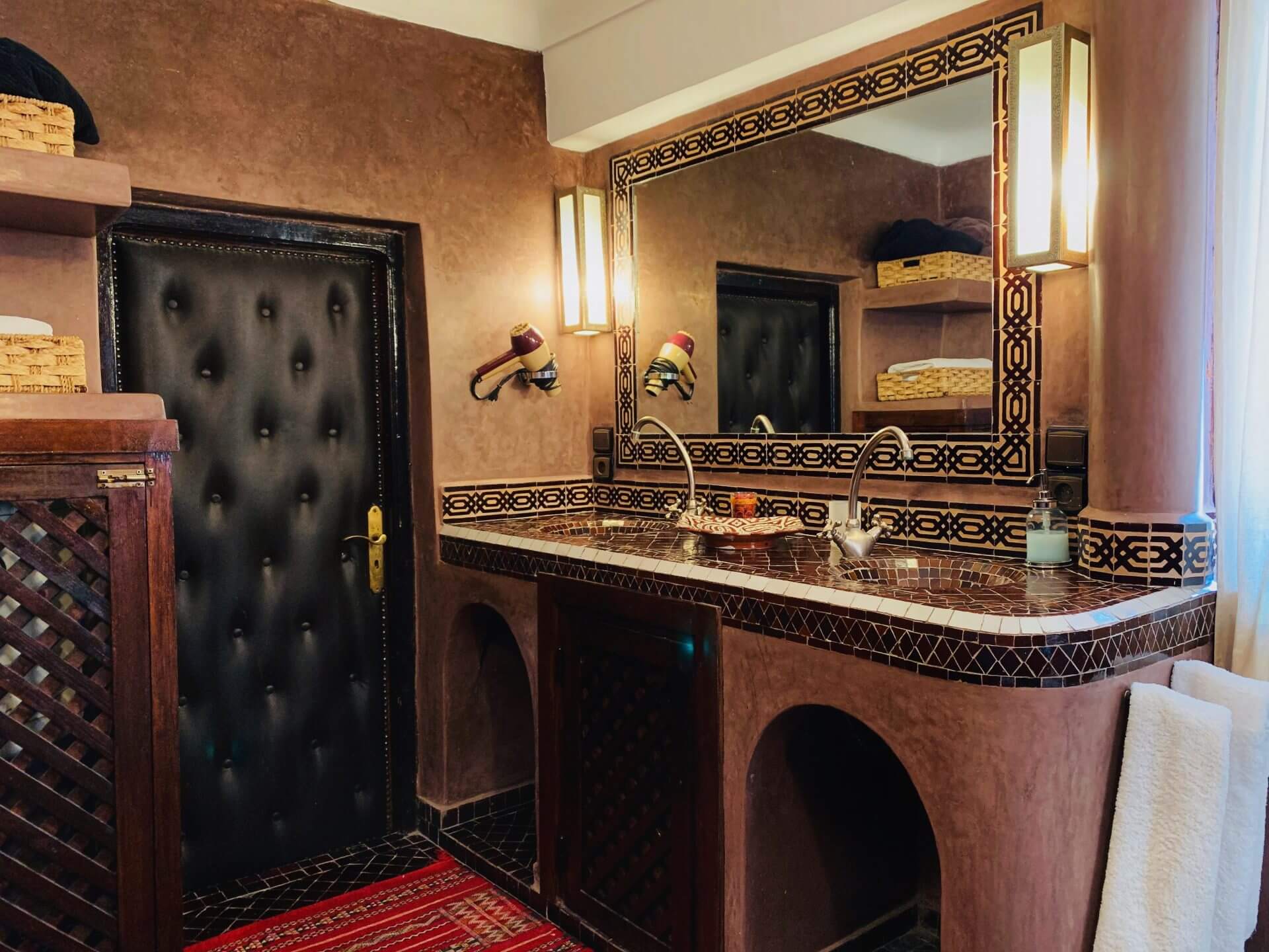 marokkanisches Badezimmer mit Waschbecken aus Mosaik und einem großem Spiegel