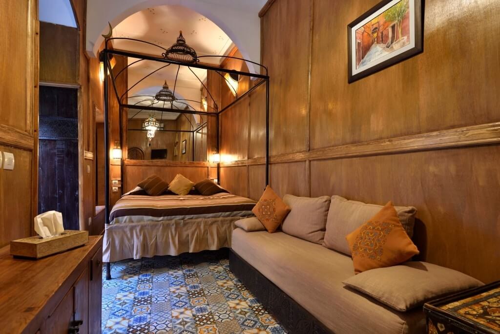 Marokkanisches Zimmer mit Wandverkleidung aus Holz, einem Bett und Sofa