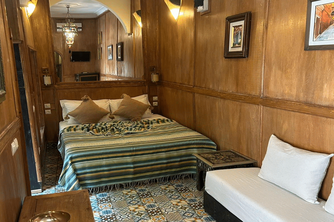 Marokkanisches Zimmer mit Wandverkleidung aus Holz, einem Bett und Sofa