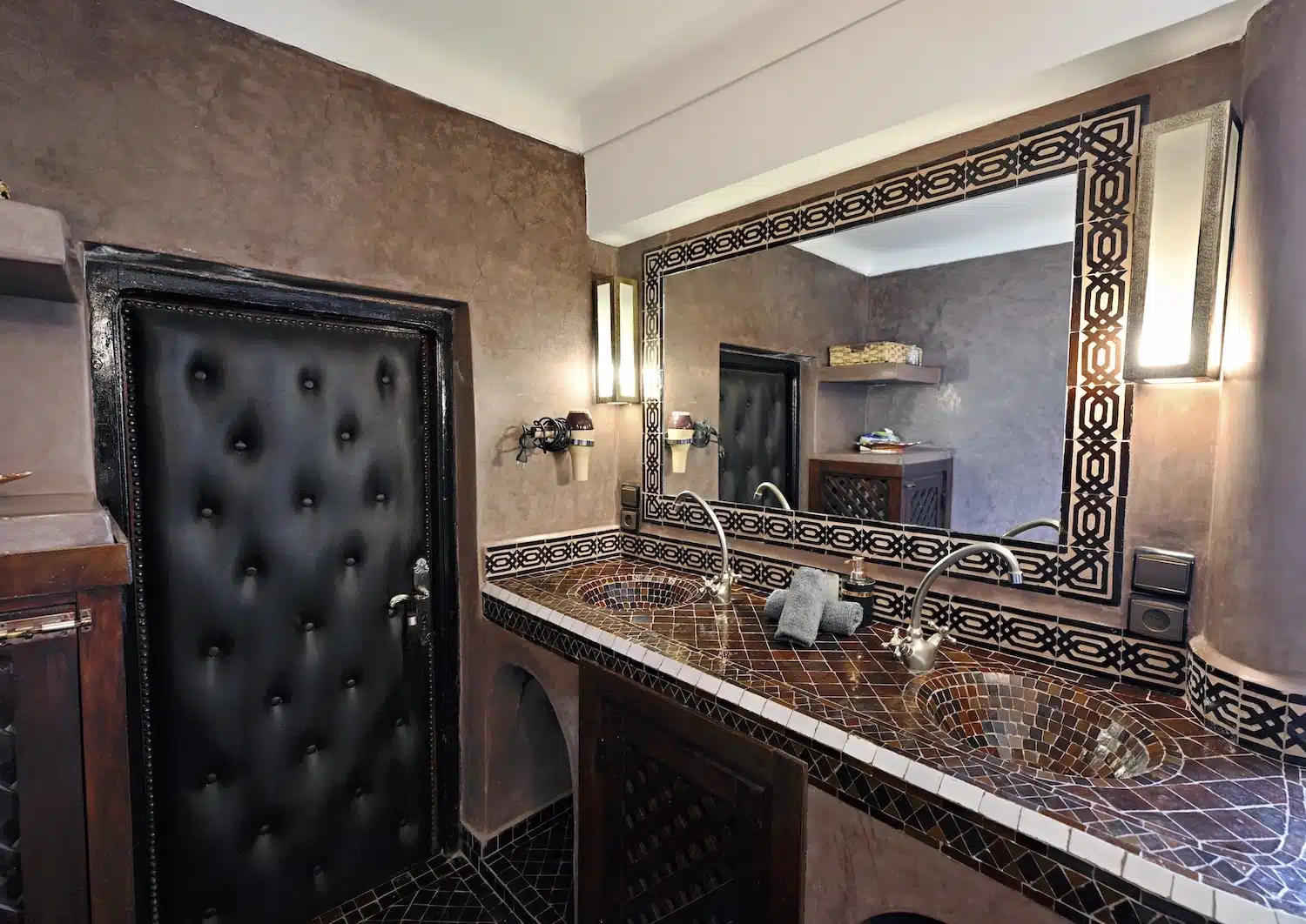 Authentisches marokkanisches Badezimmer der Suite Kara Ben Nemsi mit handgefertigten Mosaikfliesen, Messing-Armaturen und geräumiger Dusche.