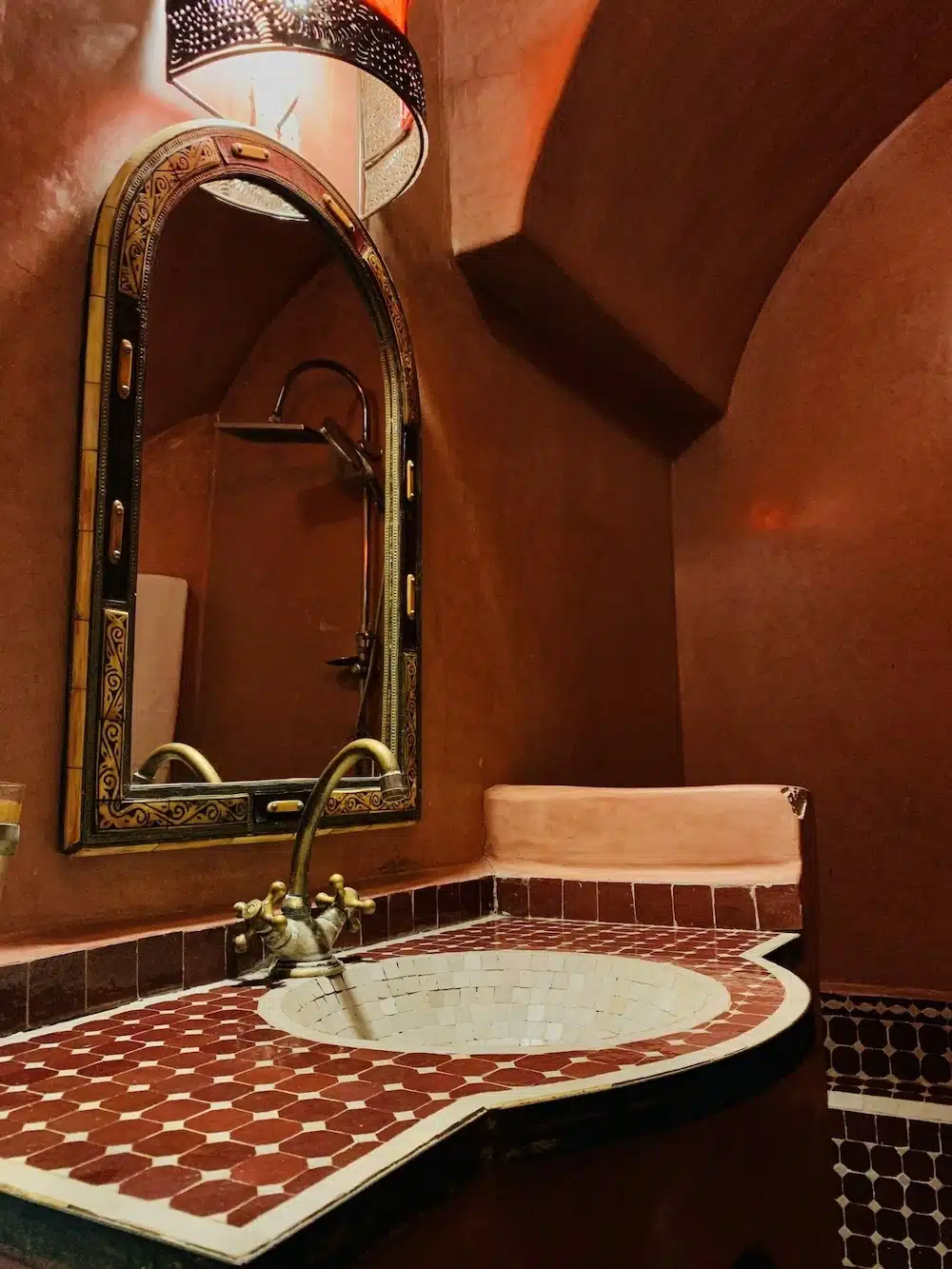 Authentisches marokkanisches Badezimmer im Zimmer Fortune mit handgefertigtem Zelije-Mosaik-Waschbecken und traditionellen Armaturen.