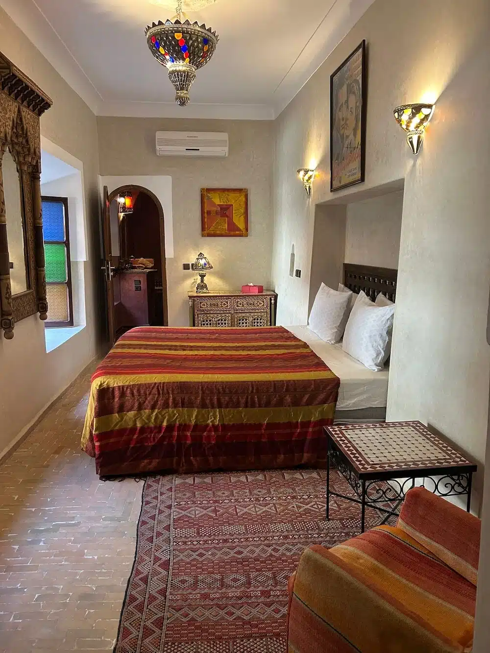 Vollständig ausgestattetes Zimmer Fortune im Riad La Maison Nomade mit Klimaanlage, Sitzecke und marokkanischen Kunsthandwerk-Details.